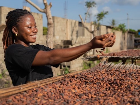 Femme qui tient des coques de cacao